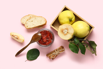 Jar of sweet jam, quince fruits and bread pieces on pink background