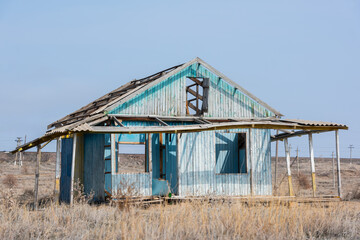 Abandoned dilapidated one-story wooden house on an autumn day in the steppe