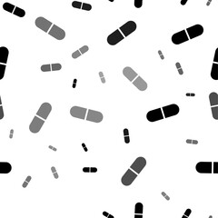 Seamless vector pattern with medical capsule symbols, creating a creative monochrome background with rotated elements. Vector illustration on white background