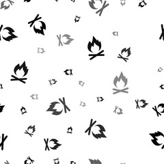 Seamless vector pattern with bonfire symbols, creating a creative monochrome background with rotated elements. Vector illustration on white background