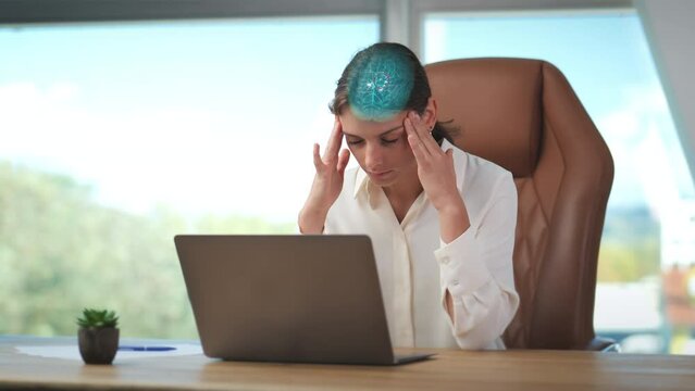Businesswoman under stress at her laptop with severe headache rubs her temples. Digital animation of brain center of pain