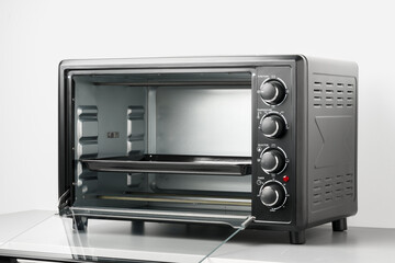 Fototapeta premium Electric mini oven on gray background studio shot
