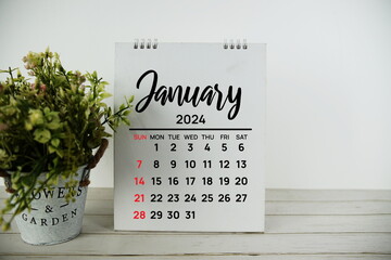 January 2024 monthly calendar with vintage alarm clock on wooden background - obrazy, fototapety, plakaty