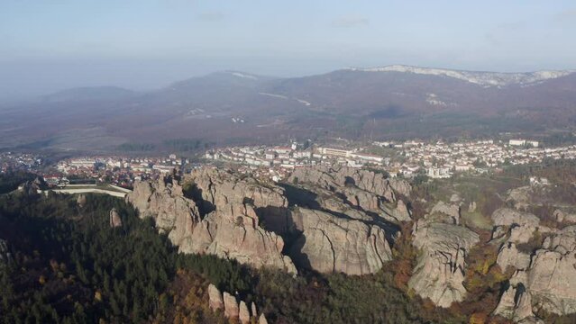 Strafing from the righ to the left to show a more panoramic view of the Belogradchik sculptural rocks, the town, ane the Balkan mountain ranges in the background in Vidin province in Bulgaria.