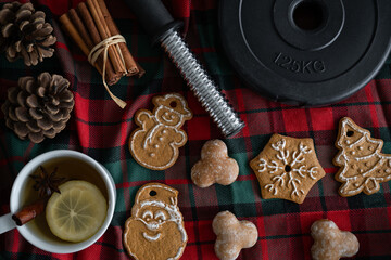 Dumbbells and gingerbread Christmas cookies. Healthy fitness composition. Gym workout, sport...
