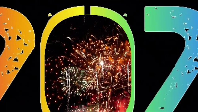 Explosion of smoke and sparkling particles of rainbow colors, generate text Happy New Year 2024, zoom in fireworks video at the night sky 