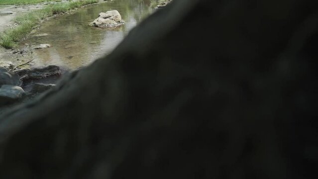Panning from the right to the lefts to slowly reveal the crystal clear mineral water flowing in the church yard of St. Petka church, nea rthe town of Rupite, Petrich in Bulgaria.