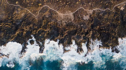 Gordijnen Drone view of Tenerife south coast with Atlantic ocean and strong swell beating against the walls of a rocky cliff, blue rough sea with big waves with foam crashing against the rocks © luciano