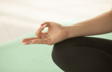 Close up of hands young woman working out on fitness mat, doing lotus yoga pose at the gym. Yoga exercise, relax and meditating, copy space. 