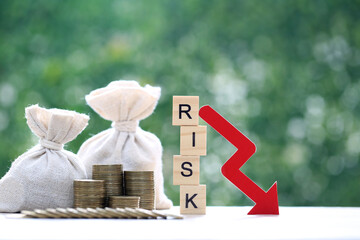 Risk word with red arrow graph and money bag on natural green background, Business investment and...