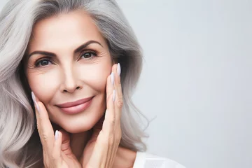 Foto op Canvas Beautiful mature woman with smooth healthy face skin. Gorgeous woman with long gray hair and happy smiling. Beauty and cosmetics skincare advertising concept. © Екатерина Переславце
