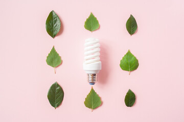 Light bulb with green leaves on pink background. Green Energy Concepts creative. Eco LED Lamp, environment sustainable. Sustainable Resources, Renewable and Environmental Care.