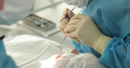 Dental treatment close-up. A dentist performs a dental procedure. Dentist's hands at work. Oral...