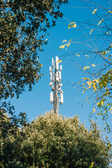 Telephone antenna among the trees, signal repeaters - 680422958
