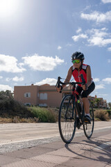 Fototapeta premium Woman in cycling clothing on a bicycle practicing for a competition. Concept of sporty, active, happy woman