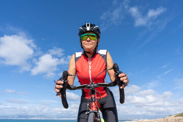 A close-up of a female cyclist riding a road bike looking ahead. Concept of sporty, active, happy woman