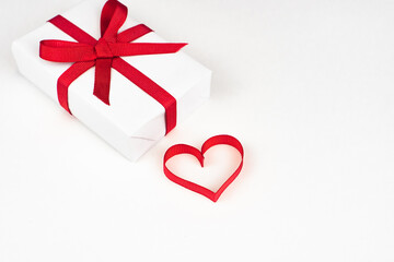 White boxes with red ribbons and decorative heart isolated on white background. Greeting card