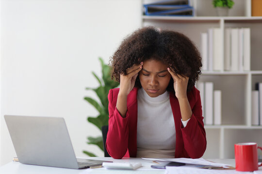 African woman in office stressed and worried about unsuccessfully working on deadlines. Stress and pressure of overwork.