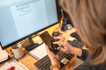 Woman dialing a phone number on mobile while teleworking from home.