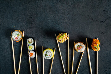 sushi with chopsticks on the dark background © Maksim Shebeko
