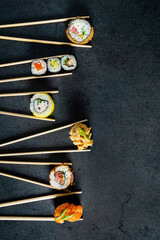sushi with chopsticks on the dark background