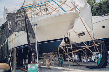 Motor yacht moored for repairs and service in dry dock - obrazy, fototapety, plakaty