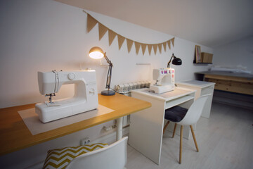 Sewing machine on table in modern sewing studio. Tailor shop