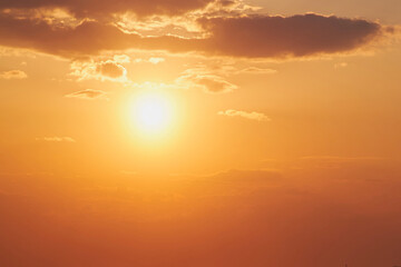 Evening sun in the sunset sky in the light of rays from behind the clouds