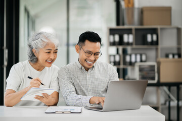 Small business owners, using laptop computer in office. Happy person, entrepreneur, small business owner working online.
