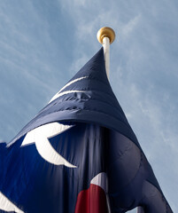 Top of a flag pole, showing the Texas lone star flag wrapped around in a cone shape