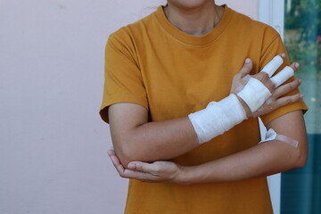 The woman wore a yellow shirt and had a bandage wrapped around her hand. After being injured while...