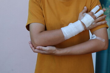 The woman wore a yellow shirt and had a bandage wrapped around her hand. After being injured while cooking