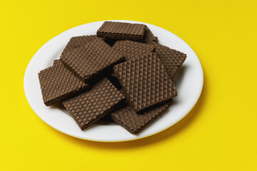 A pile of square waffles with chocolate filling on a plate