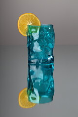 blue coctail glass with ice and lemon