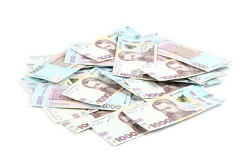 Thousand banknotes hryvnia lying in a heap isolated on white background