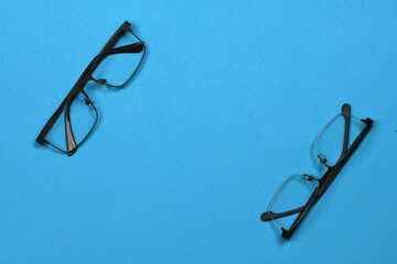 Pair of reading glasses isolated on blue background. Fashion spectacles for man and woman