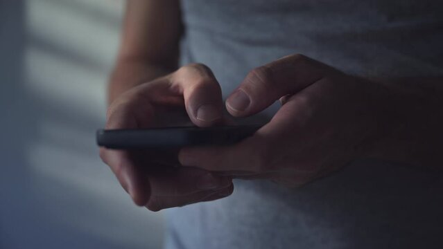 Closeup shot of male hands using mobile phone, man typing message on smart phone, communication and social media concept
