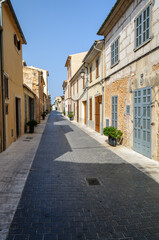 Fototapeta na wymiar Window shutters areclosed in an empty street, Sant Llorenc, Mallorca/Majorca