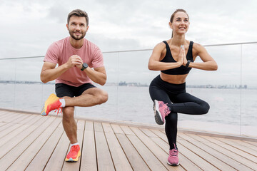 Motivation for a healthy lifestyle and training every day. Warm-up woman and man runners man fitness interval exercises, preparation for training.
