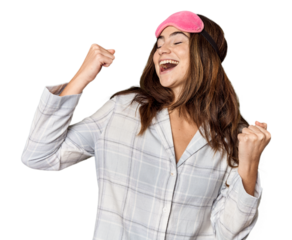 Young Caucasian woman in pajamas with mask raising fist after a victory, winner concept.