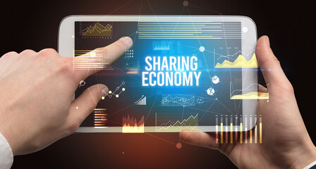 Close-up of hands holding tablet with business inscription