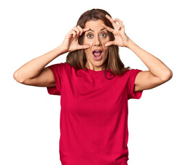 Middle-aged woman portrait in studio setting keeping eyes opened to find a success opportunity.