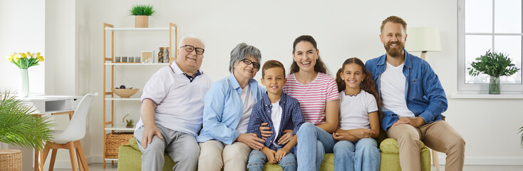 Banner background with a group portrait of a happy extended multigenerational family. Cheerful,...