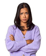Young Filipina with long black hair in studio unhappy looking in camera with sarcastic expression.