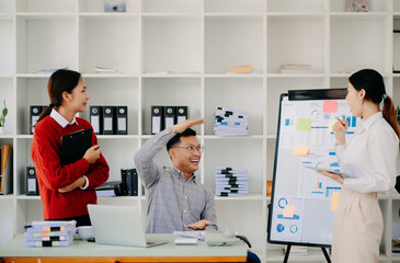 Obraz premium Office colleagues have a casual discussion. During a meeting in a conference room, a group of Asian business teem sit in the conference room new startup project..