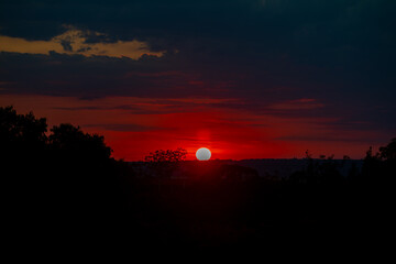 Obraz premium Orange sunrise on the horizon with emphasis on the sun's rays and birds in the distance. Idyllic Setting