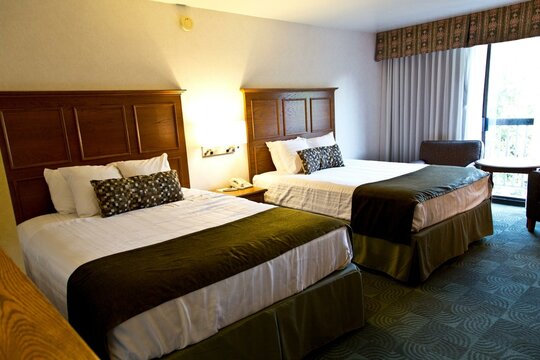 4K Image: Elegant Luxury Hotel Room with Two Queen Size Beds, Stylish Lamps, and Plush Pillows