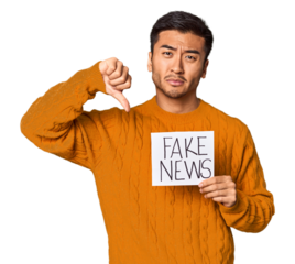 Chinese man showing "fake news" sign with skeptical expression in studio.