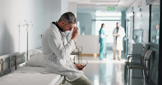 Stress, grief or mistake with a mature doctor in a hospital looking tired of healthcare or medicine career. Depression, fail or loss with a sad man medical worker in a professional medicare clinic