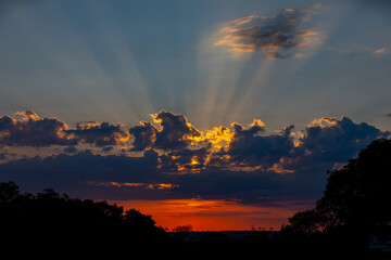 Orange sunrise on the horizon with emphasis on the sun's rays and birds in the distance. Idyllic Setting